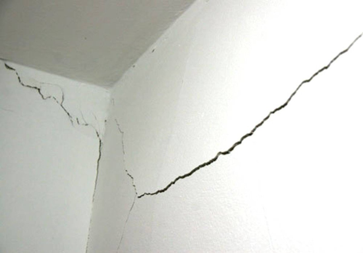 Трещина лежать. Трещины на штукатурке. Усадочные трещины в штукатурке. Стена потрескавшаяся штукатурка. Трещина в углу стены.